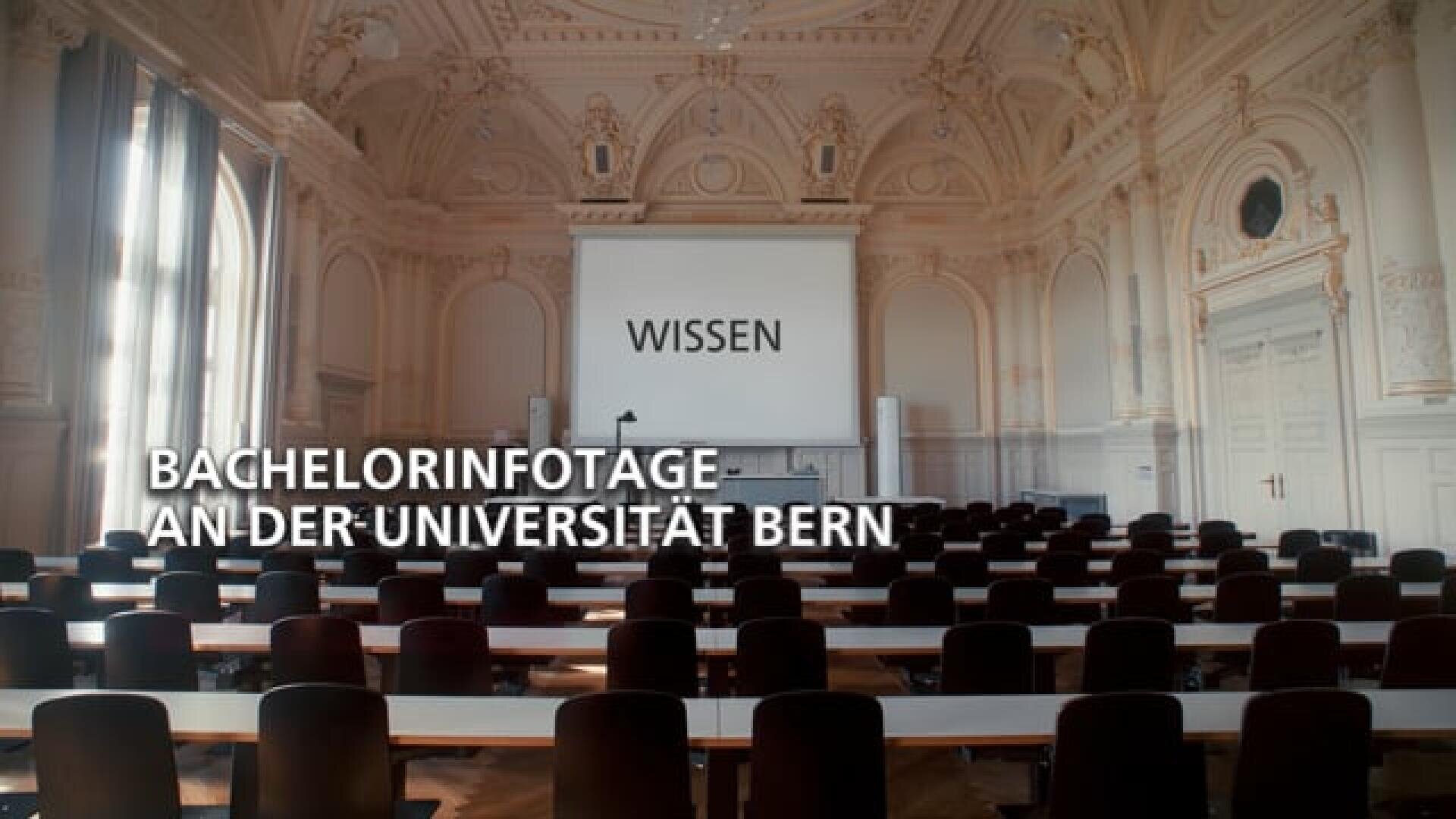 Grosser, eleganter Hörsaal mit verzierten Decken und Reihen von leeren Tischen an der Universität Bern. Auf einer Projektionsfläche erscheint das Wort WISSEN. Der Text darüber lautet: BACHELORINFOTAGE AN DER UNIVERSITÄT BERN.