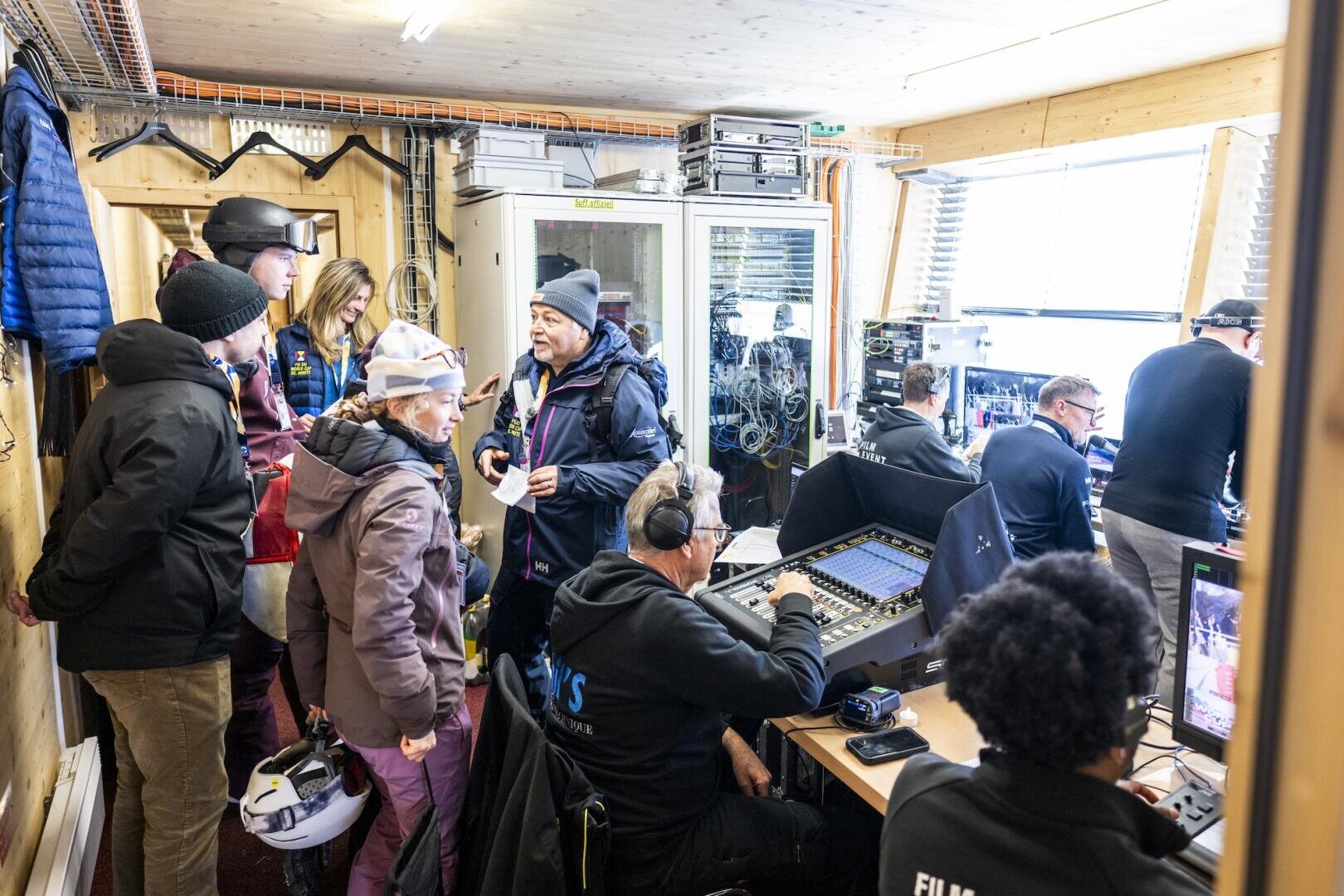 Tourismusstudierende auf der Backstageführung im Regieraum von SRF am FIS Skiweltcup St. Moritz. Der Raum ist mit Audio- und Videogeräten, Computern und Monitoren ausgestattet.