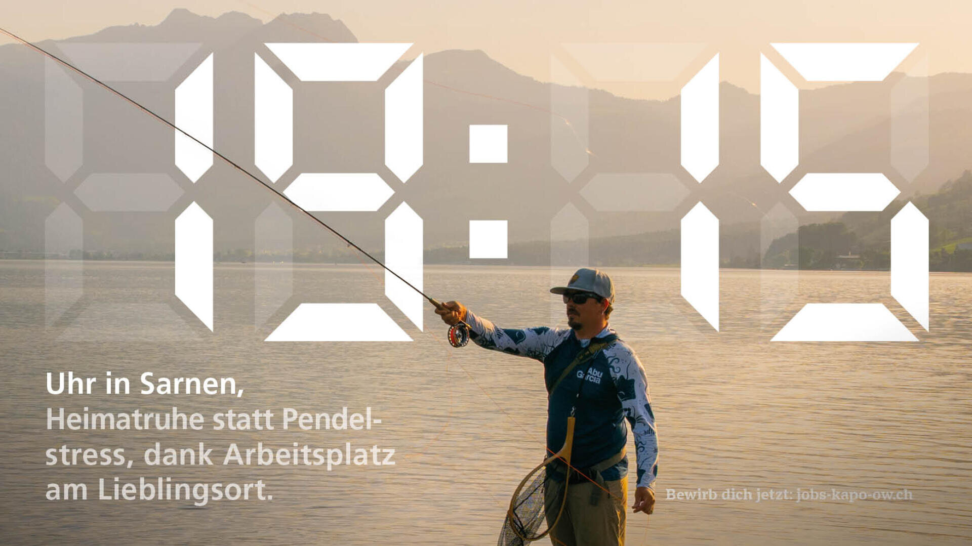 Eine Person in Angelausrüstung wirft eine Angelschnur an einem ruhigen See bei Sonnenuntergang aus, Berge im Hintergrund. Große durchscheinende Zahlen 19:15 überlagern das Bild. Der deutsche Text wirbt für lokale Arbeitsmöglichkeiten.