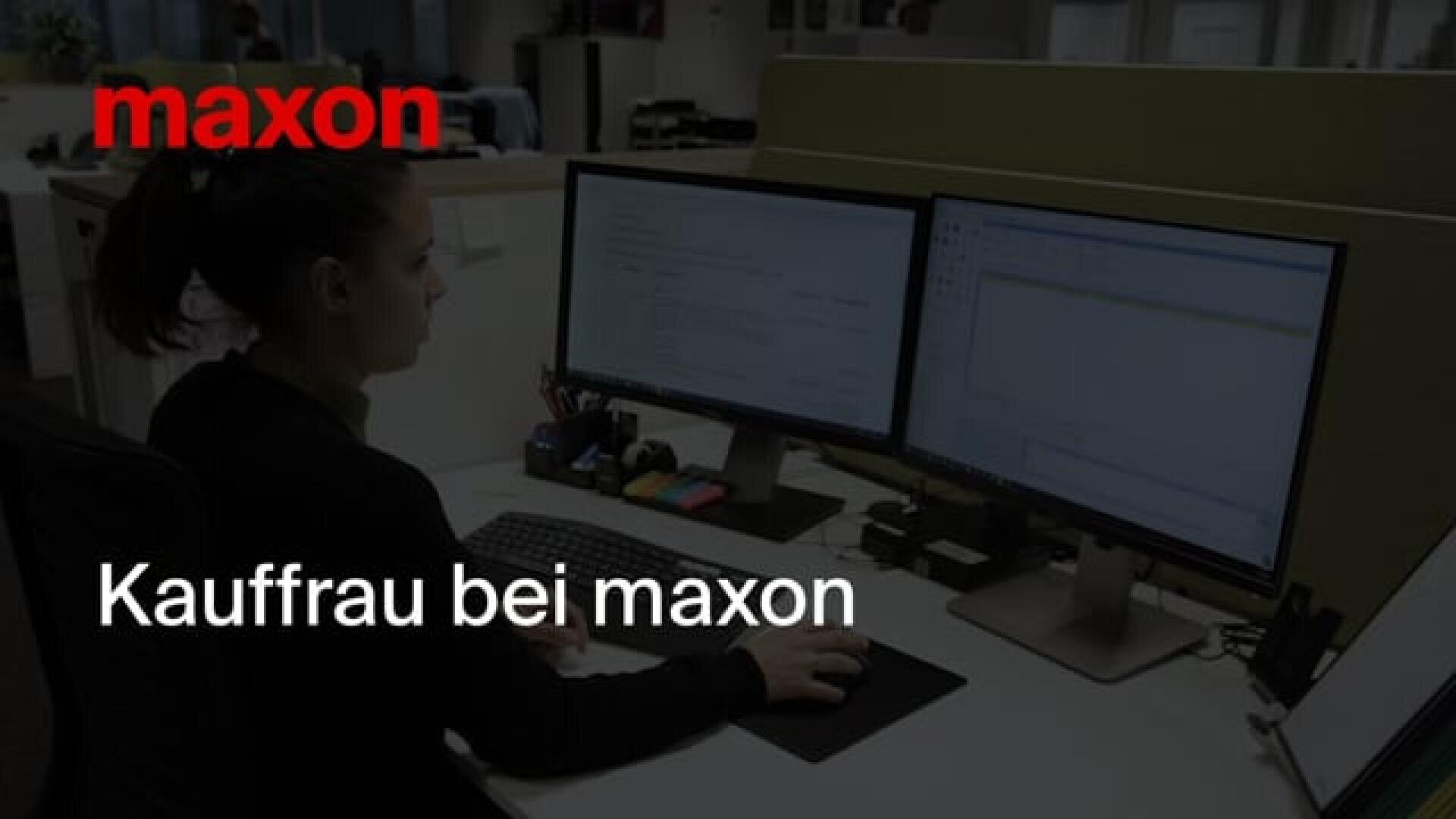 Eine Frau arbeitet an einem Schreibtisch mit zwei Computermonitoren; über das Bild sind die Schriftzüge maxon und Kauffrau bei maxon eingeblendet.