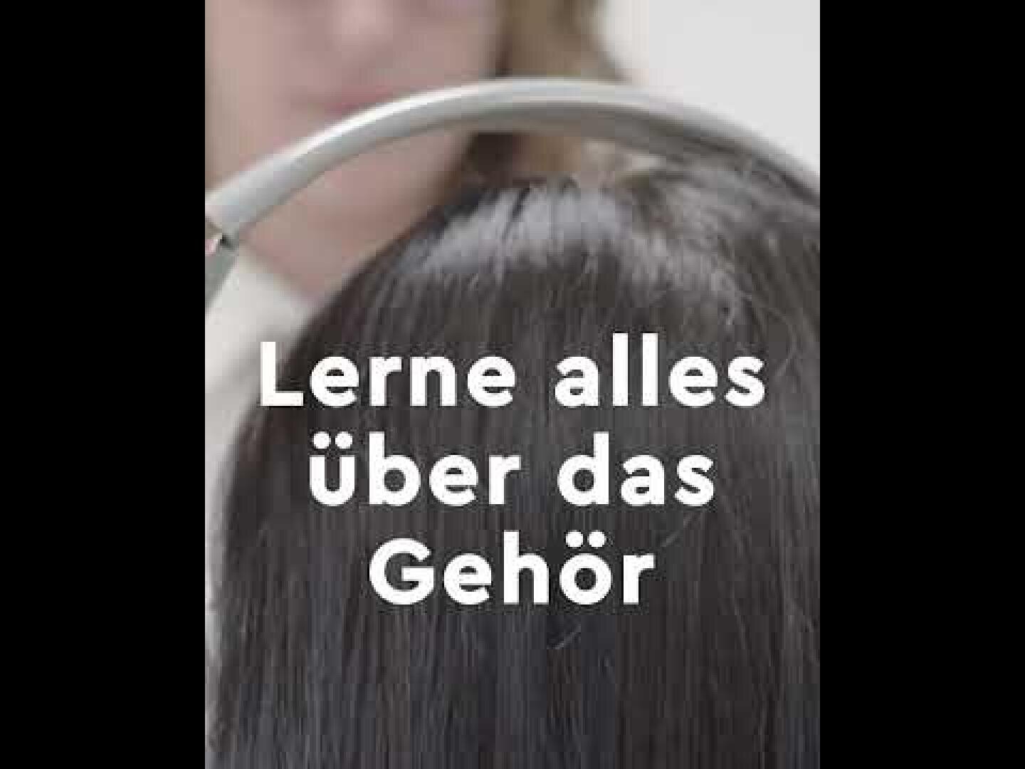 Eine Person hält ein medizinisches Gerät über den Kopf einer Person. Der deutsche Text auf dem Bild lautet "Lerne alles über das Gehör", was so viel bedeutet wie "Lerne alles über das Gehör".
