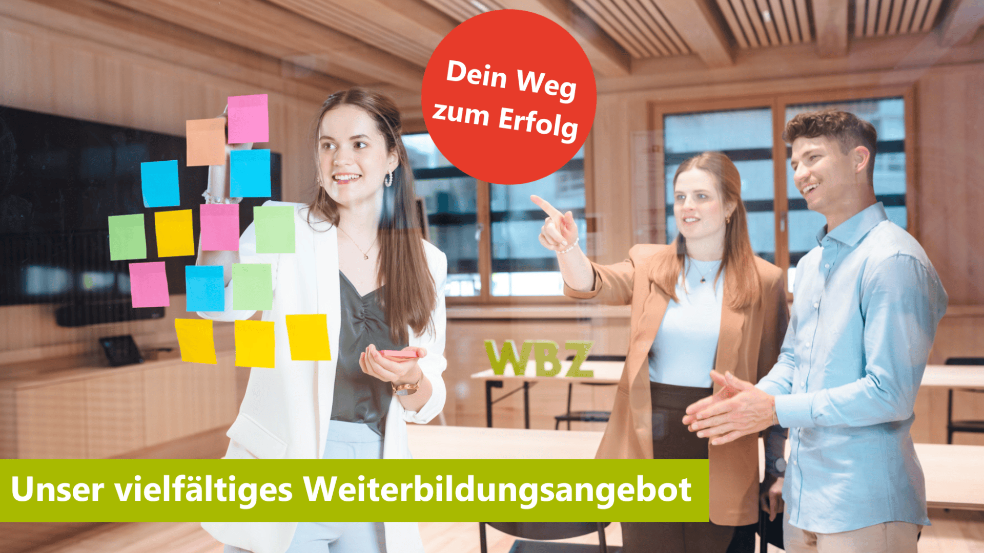 Drei junge Erwachsene stehen in einem modernen Raum. Eine Frau bringt bunte Post-its an eine Glasscheibe an, zwei andere schauen zu. Text: "Dein Weg zum Erfolg" und "Unser vielfältiges Weiterbildungsangebot".