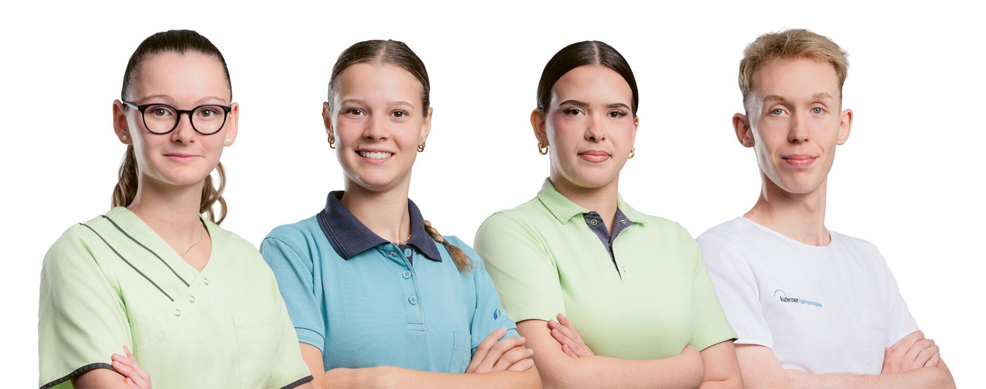 Vier junge Erwachsene in unterschiedlichen Uniformen stehen nebeneinander, lächeln und blicken nach vorne, vor einem weißen Hintergrund.
