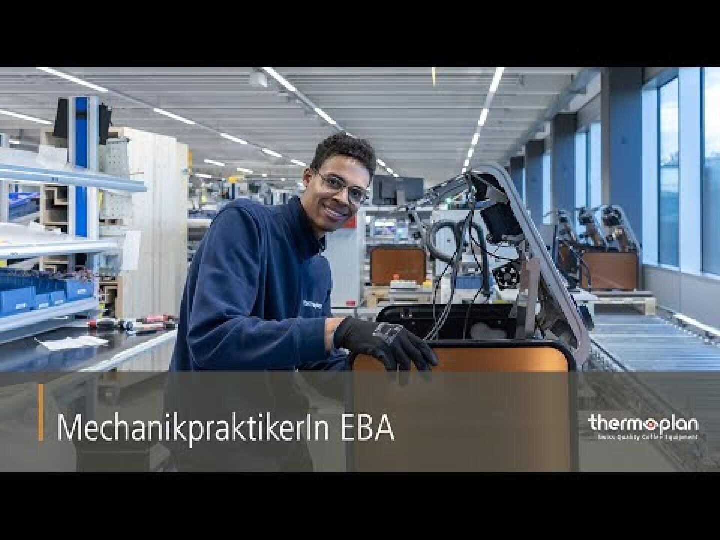 Eine Person mit Brille und Handschuhen lächelt, während sie in einer hellen, aufgeräumten Werkstatt an einer Maschine arbeitet. Der Text lautet: „MechanikpraktikerIn EBA“ und „thermoplan“.