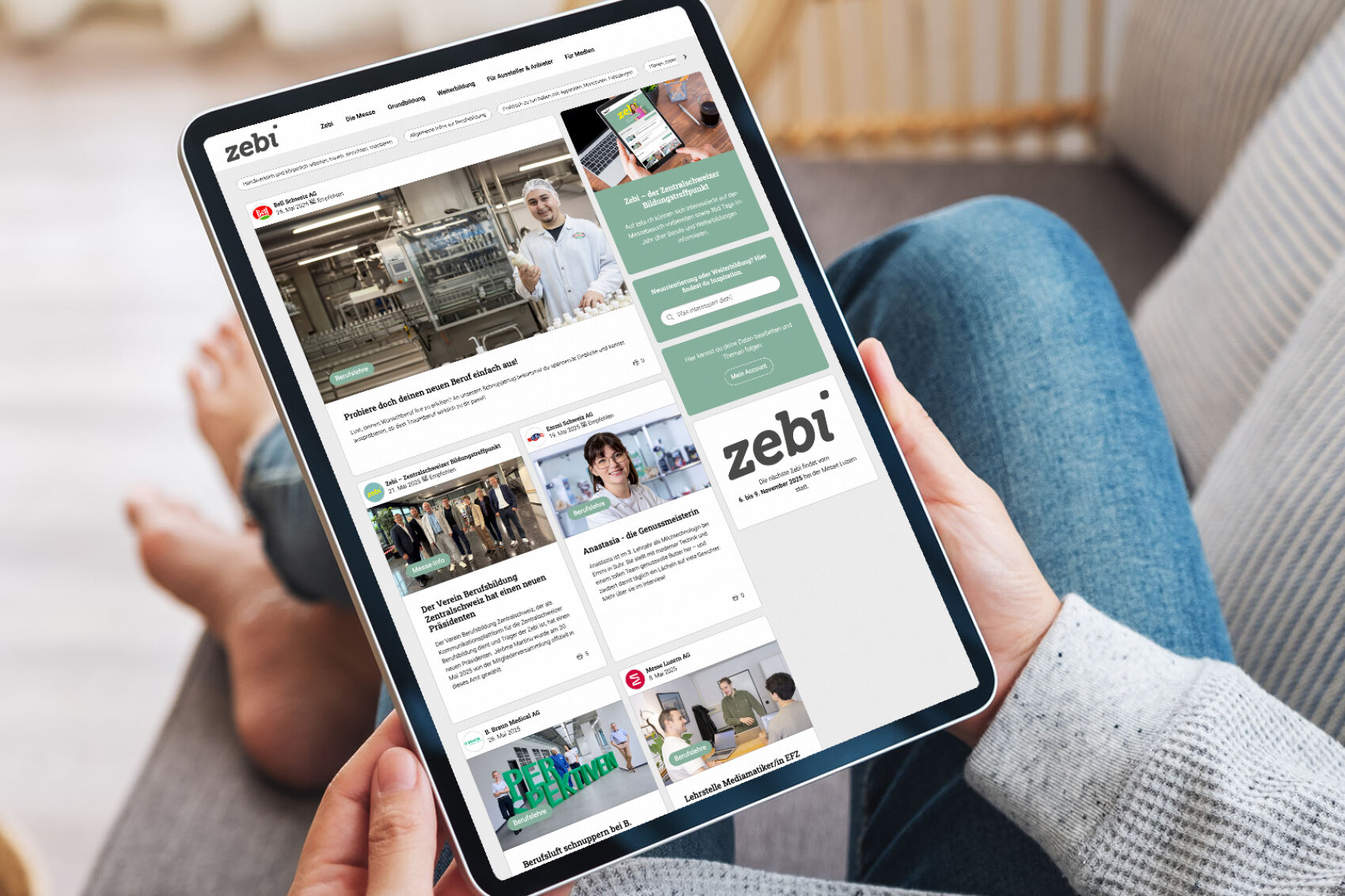 Eine Person hält ein Tablet, auf dem die Luga-365-Webseite geöffnet ist. Sie zeigt ein Bild von einem Produkt, das vor einem Bergsee präsentiert wird. Im Hintergrund sind Beine in bequemer Sitzhaltung zu sehen.